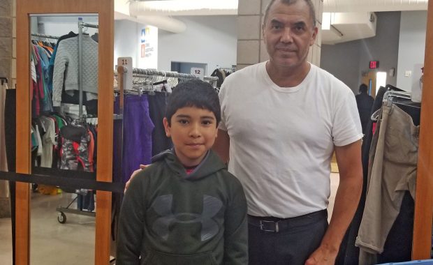 Father and son stop to show off a green hoodie that's just right during their shopping trip in the Free Store.