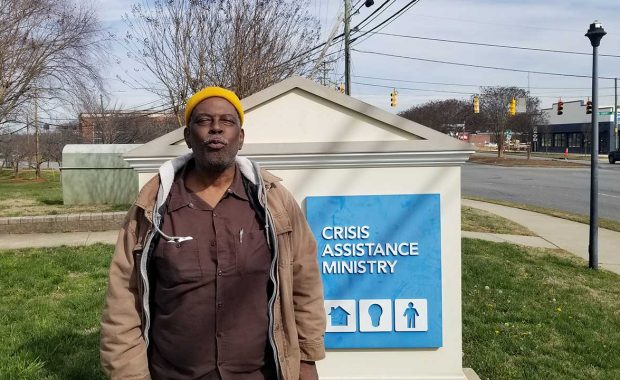 Myron stands in front of Crisis Assistance Ministry sign